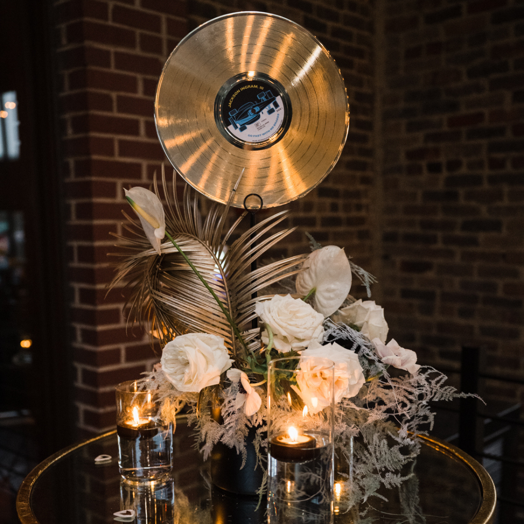 Centerpiece for the IndyCar event in Nashville - features a record player, elegant florals and feathers, as well as lit candles